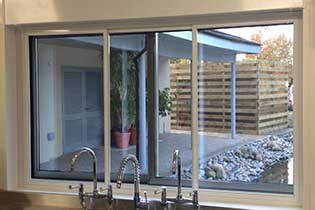 Image of a window fly screen, showcasing a fine mesh material that effectively blocks insects while allowing fresh air and natural light to enter. The screen is framed to fit snugly within the window opening, featuring a simple design that blends seamlessly with the window aesthetics, providing a practical solution for pest prevention