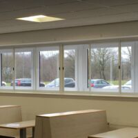 Sliding fly screens along a full run of windows Row of sliding fly screens along a canteen's windows