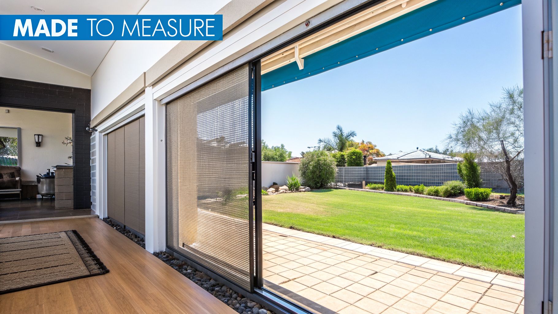 Fly Screens Large sliding doors with a partially open mesh fly screen overlooking a green backyard and patio.